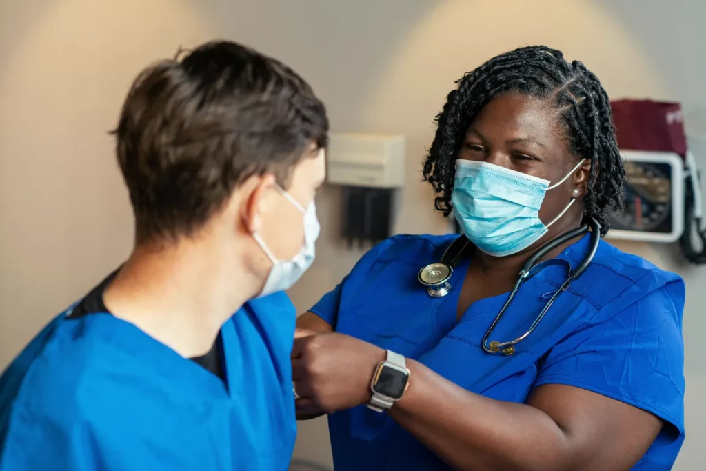 A health care provider bandages a patient's arm after a flu shot