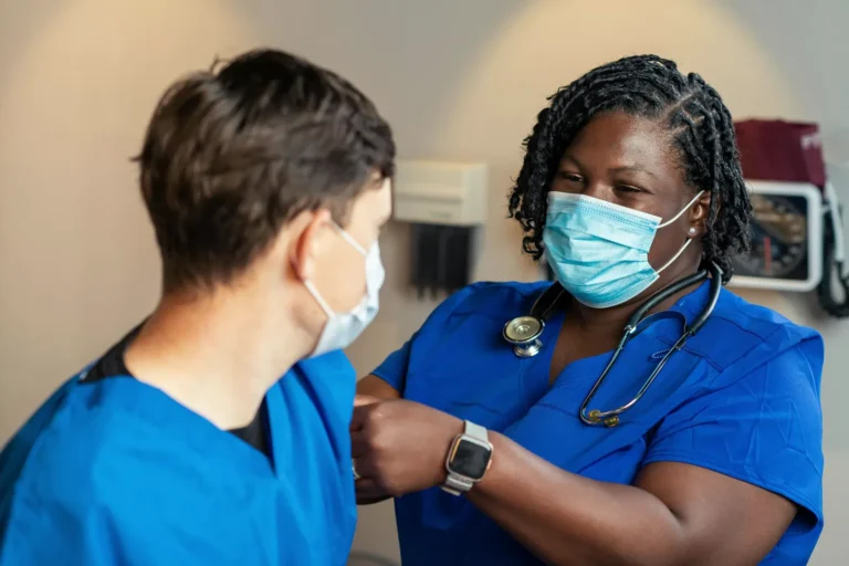 A health care provider bandages a patient's arm after a flu shot